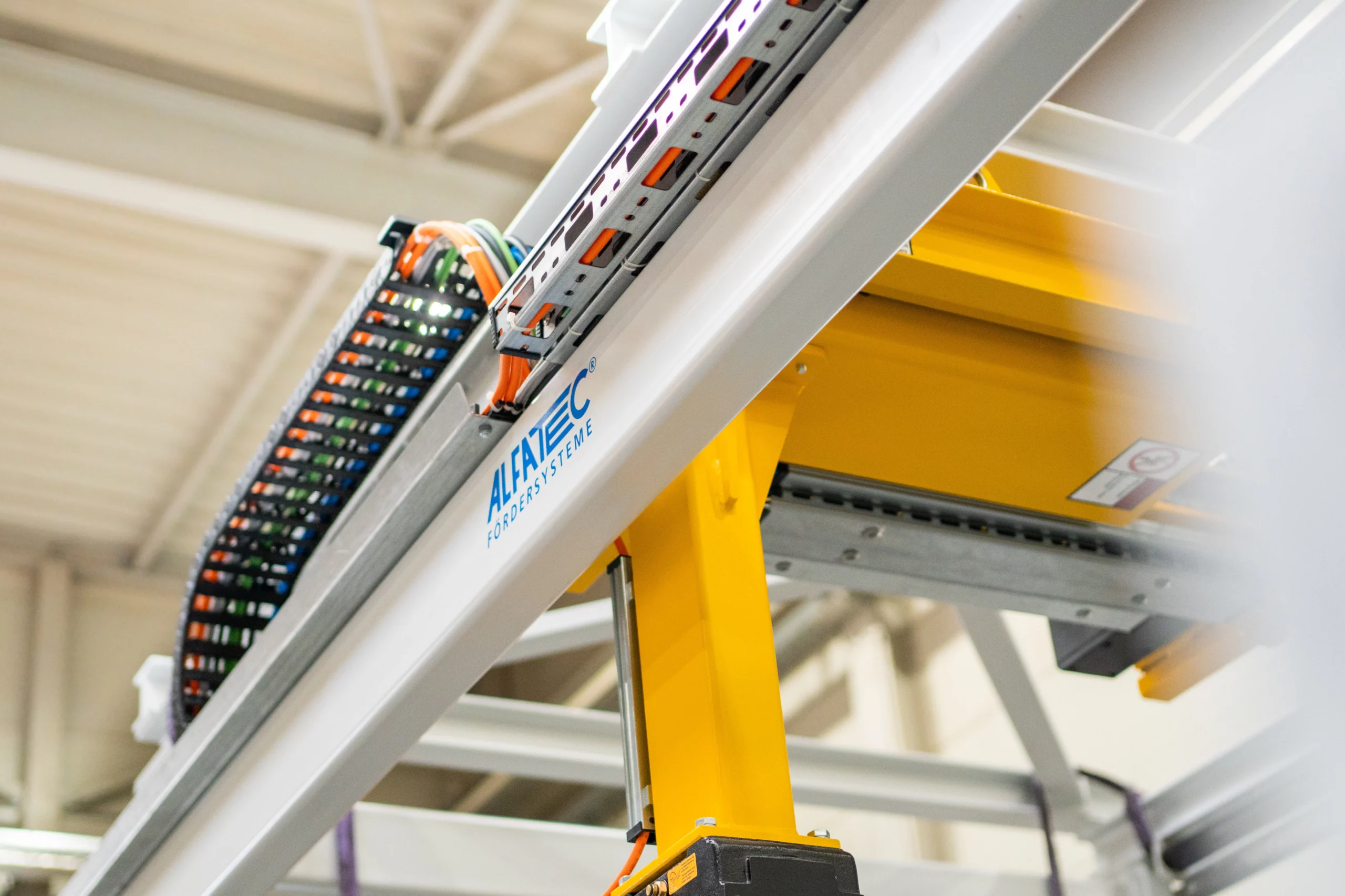 Individuelles Fördersystem von ALFATEC in Industrieanlage Fördertechnik mit Energiekette und Führungsschiene von ALFATEC
