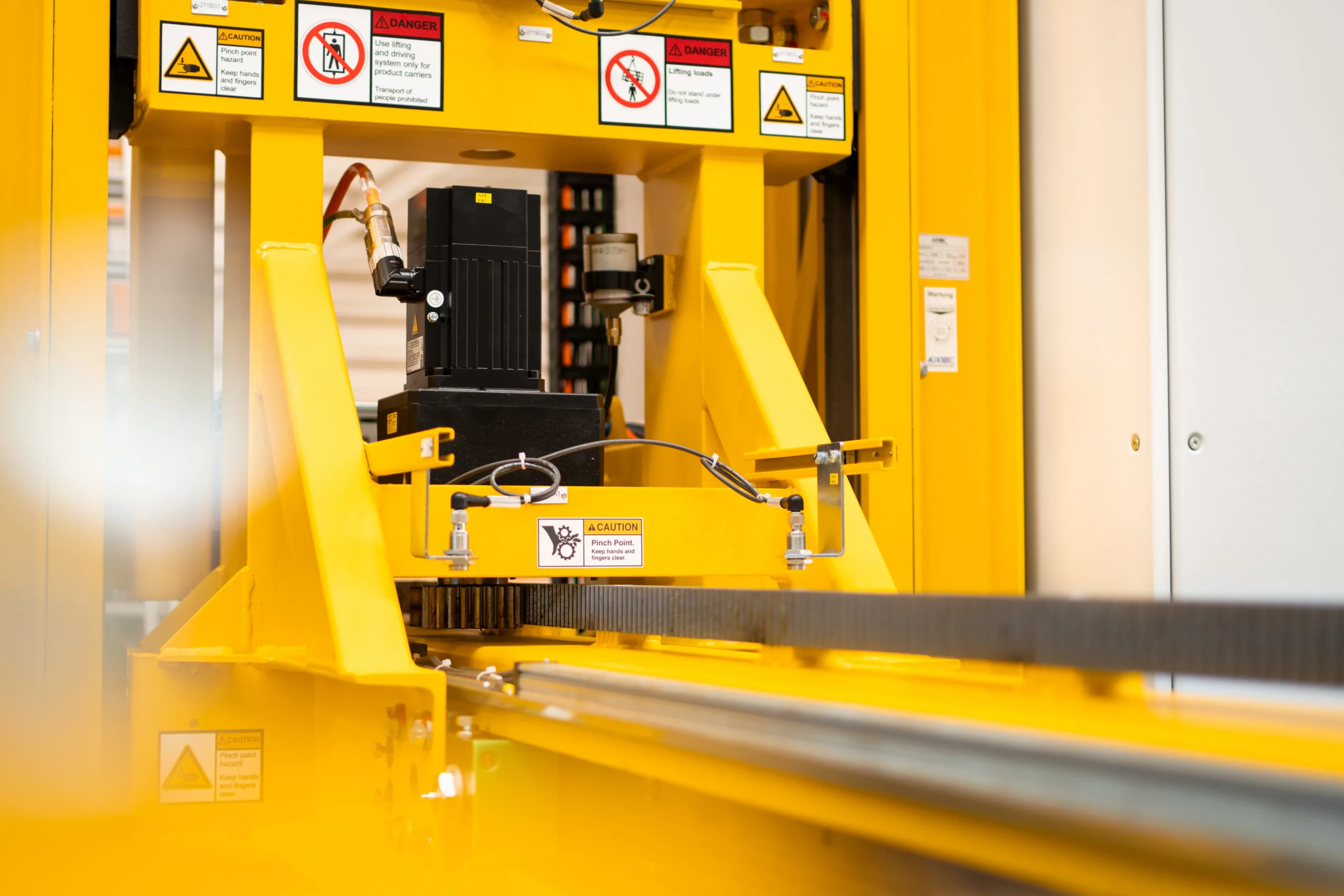 Antriebseinheit und Führung eines Fördersystems mit Motor und Zahnstange in industrieller Anwendung