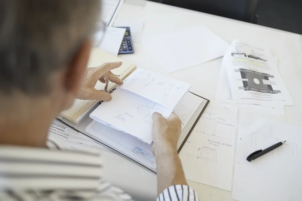 A binder with the plans of a handling system on a desk.